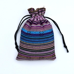 Detail of bohemian drawstring gift bag featuring colorful woven ethnic stripe patterns