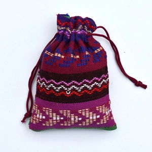 Detailed view of wine red ethnic drawstring pouch with geometric woven pattern