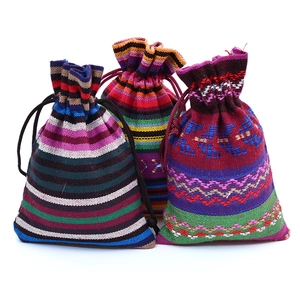 Detailed view of three ethnic style woven drawstring pouches with colorful stripes