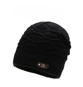 Detail of black knit beanie with thickened wave texture and classic brown leather patch