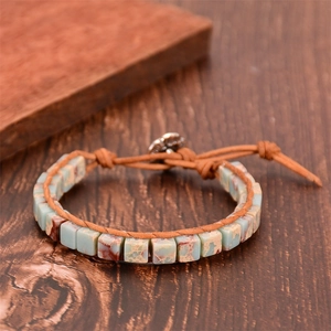 Gros plan d'un bracelet bohème en perles de pierre naturelle avec fermoir fleur en métal