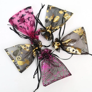 Detailed view of Halloween organza gift bags with gold bat and spider web patterns