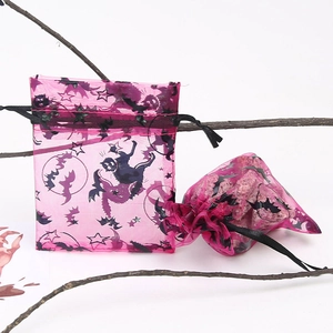 Detailed view of pink mesh gift bags with black moon and star patterns for Halloween