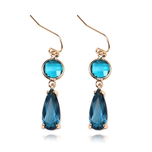 Detailed macro shot of dark blue teardrop crystal earring with golden copper trim