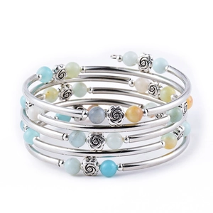 Detail of bohemian multilayer wrap bracelet with turquoise beads and metal rose charms