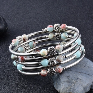 Detailed close-up of multi-layer beaded bracelet with silver roses and marble beads