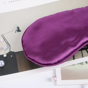 Close-up of a purple faux silk sleep mask with smooth texture and glossy finish