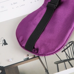 Detail view of purple satin silk sleep mask featuring adjustable black elastic strap