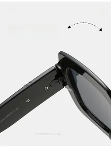Vue détaillée de la charnière et des codes de taille sur les lunettes de soleil carrées noires