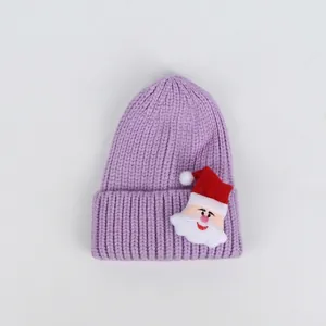 Dettaglio del berretto in maglia a coste viola con toppa decorativa di Babbo Natale