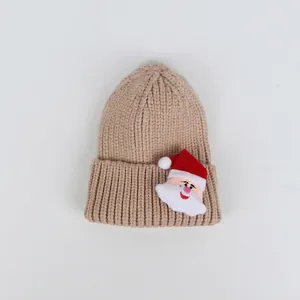 Dettaglio del berretto in maglia con patch Babbo Natale 3D per tema natalizio