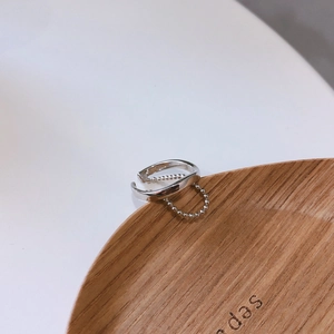 Detail of minimalist 925 sterling silver double-layer chain ring on a wooden tray