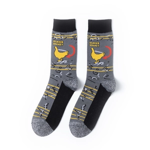 Detail view of gray cotton socks with yellow chicken pattern and GUESS WHAT text