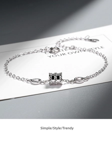 Close-up of S925 sterling silver hourglass charm bracelet with geometric engraving
