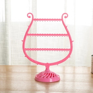 Pink harp-shaped jewelry organizer with four-tier earring holes and necklace hooks