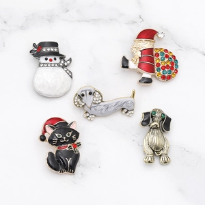 Detail of five Christmas brooches featuring Santa and animals on marble background