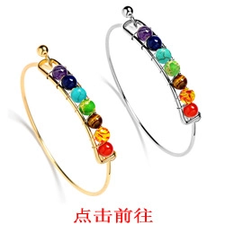 Detailed view of two minimalist open bracelets with seven colorful chakra energy beads