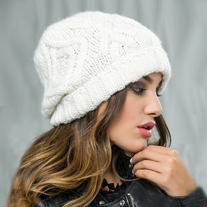 Close-up of white knitted beanie showing soft diamond pattern texture and warm fiber detail