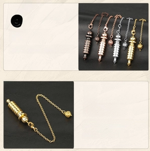 Detail view of metallic healing pendulums in four colors on a black leather background