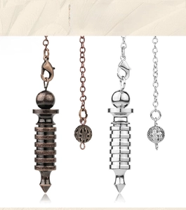 Macro detail of bronze and silver plated spiritual dowsing pendulums with metal chains