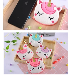 Macro view of plush unicorn coin purse showing compact size next to a mobile phone