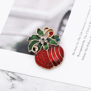 Detail of Christmas holly leaf brooch in gold metal with red and green rhinestones