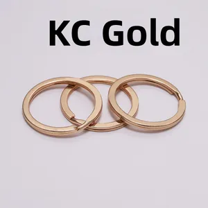 Detailed view of three flat KC gold plated metal key rings with double-layered structure