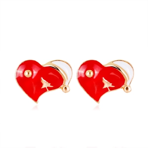 Detail of heart-shaped Christmas earrings with Santa hat and gold tree silhouette