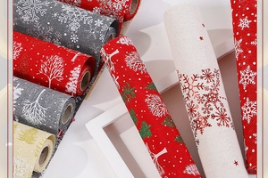 Close-up of linen Christmas table runners with snowflake and tree patterns in neutral tones