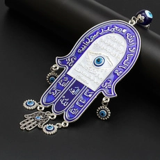 Detailed view of silver Hamsa hand amulet with blue Evil Eye and Arabic calligraphy