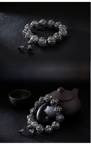 Macro shot of stainless steel beads with mantra engraving and small bell charms