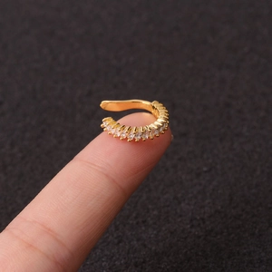 Macro shot of gold-plated U-shaped ear cuff featuring clear rectangular zircon stones