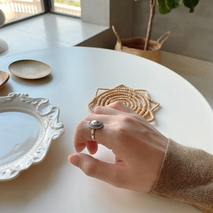 Detailed view of vintage 925 silver mirror ring with beaded texture worn on finger