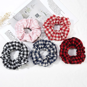Vue à plat de cinq chouchous en tissu à carreaux variés aux motifs colorés divers