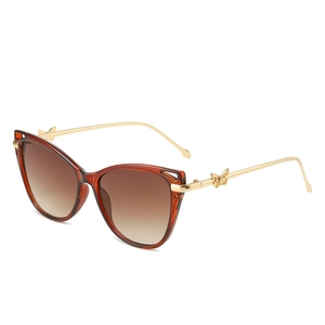 Amber cat-eye sunglasses with gold metal temples and unique butterfly accents