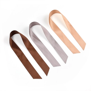 Detailed macro view of satin ribbons in dark coffee, grey, and light beige color options