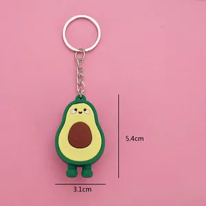 Cartoon avocado keychain in green soft PVC with metal ring on a pink background