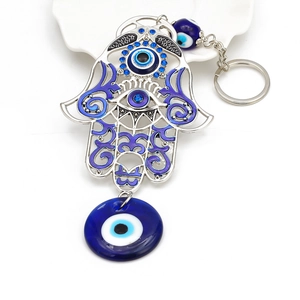Macro shot of silver Hamsa Hand keychain with blue evil eye beads and crystal charms