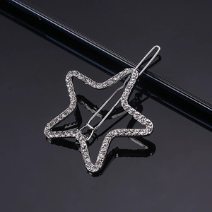 Macro shot of silver pentagram hair clip with sparkling rhinestones on black surface