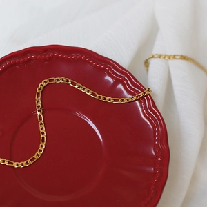Gouden titanium stalen kralen ketting met watergolfpatroon op een rood bord