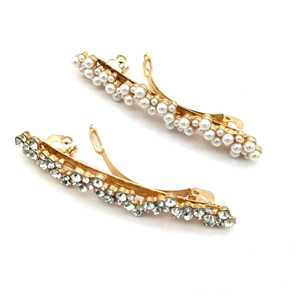 Détail de barrettes dorées à ressort avec perles blanches et strass brillants clairs