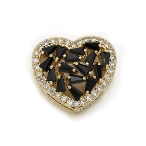 Macro view of heart-shaped gold charm with clear and black zircons inlay detail