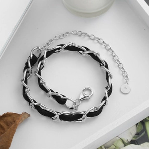 Macro shot of silver snake chain with black leather weaving and 925 silver stamp