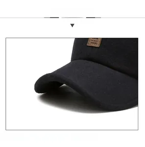 Detail view of the black wool baseball cap with a brown leather logo label and visor