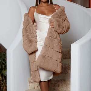 Close-up of fluffy texture on long brown faux fur coat paired with a white satin dress