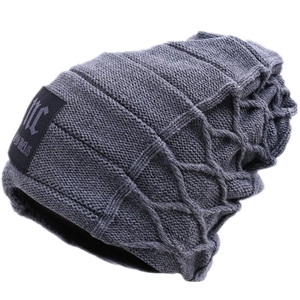 Detail of dark grey knit beanie showing the diamond texture and woven MC fabric label