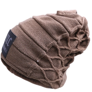 Detail shot of a dark brown knit beanie showing ribbed texture and decorative black fabric patch
