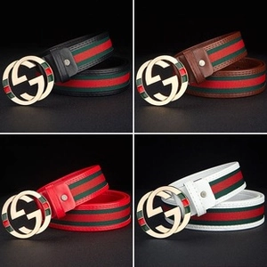 Detail of four colorful canvas belts with metallic double G buckles and striped pattern