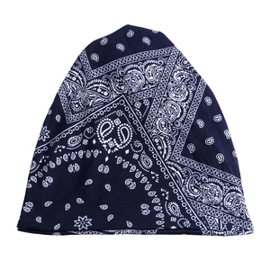 Détail de l'imprimé paisley bleu foncé et de la texture du tissu de ce bonnet souple