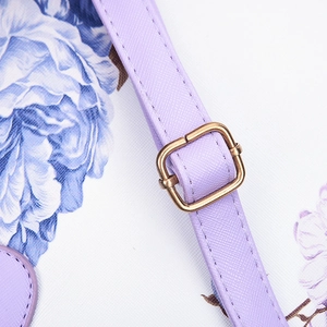 Close-up of purple textured leather shoulder strap with golden metal adjustment buckle